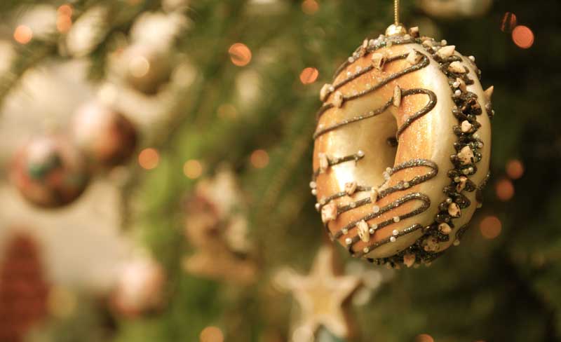 Glazed donut ornament hanging on a Christmas tree